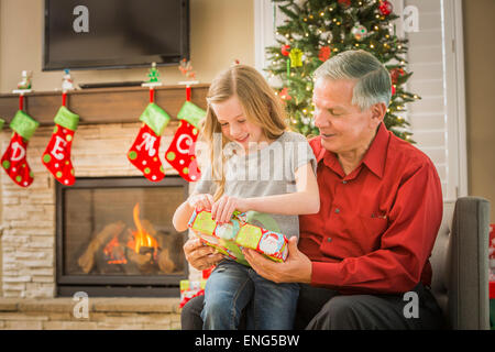 Caucasian grandfather opening Christmas gifts with granddaughter Stock Photo
