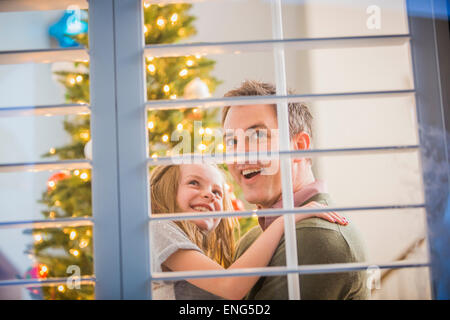 Caucasian father and daughter looking for Santa at Christmas Stock Photo