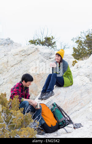 Couple sharing coffee on rock formations Stock Photo