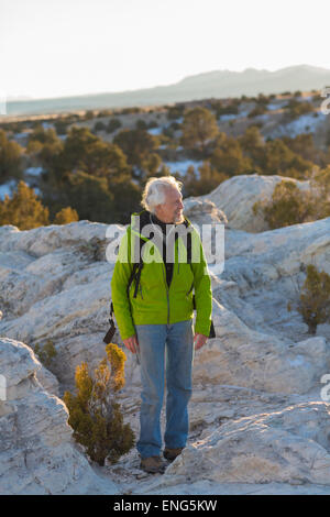 Older man standing on remote rock formations Stock Photo