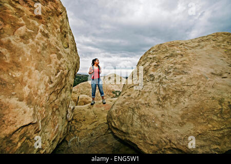 Hispanic woman hiking on rock formations Stock Photo