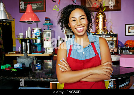 Mixed race barista smiling in coffee shop Stock Photo