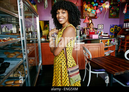 Mixed race woman buying pastries in bakery Stock Photo