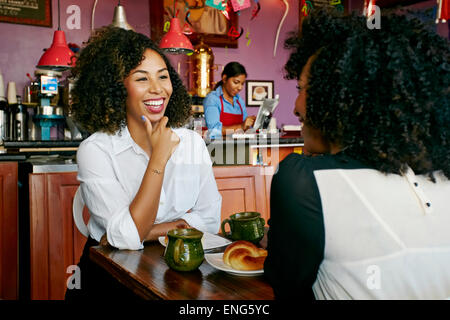 Women drinking coffee and talking in cafe Stock Photo