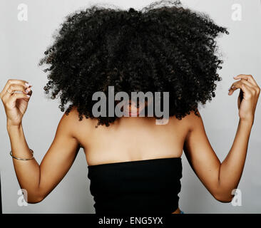 Close up of mixed race woman with curly hair looking down Stock Photo