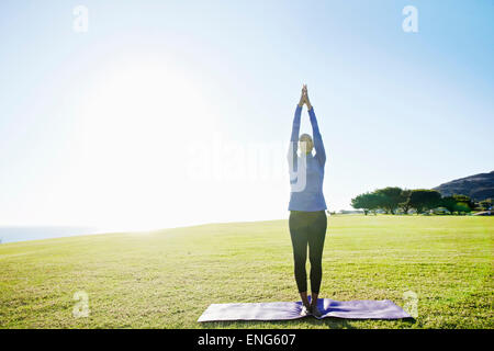 African American woman practicing yoga in park Stock Photo