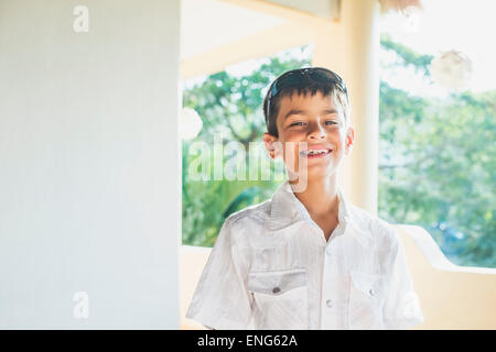 Mixed race boy smiling on porch Stock Photo