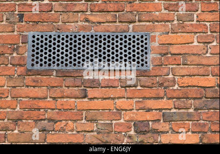 Brick wall with old iron ventilation plate Stock Photo