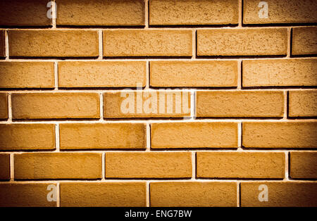 Brickwall made up of orange bricks with added saturation and vignetting Stock Photo