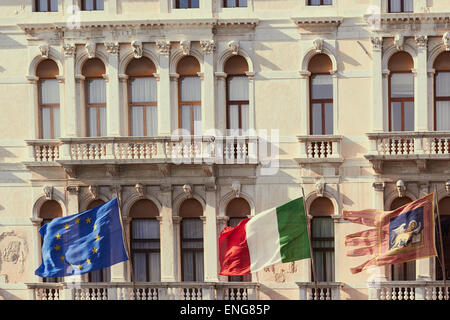 European union Italian and Venetian flags flying on the Palazzo Ferro Fini Venice Veneto Italy Europe Stock Photo