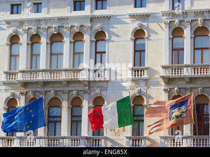 European union Italian and Venetian flags flying on Palazzo Ferro Fini Venice Veneto Italy Europe Stock Photo