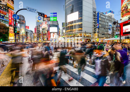 Pedestrians walk at Shibuya Crossing during the holiday season. The scramble crosswalk is one of the largest in the world. Stock Photo