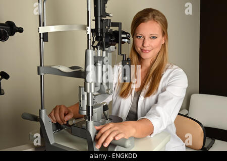 Portrait of female eye doctor using equipment in office Stock Photo