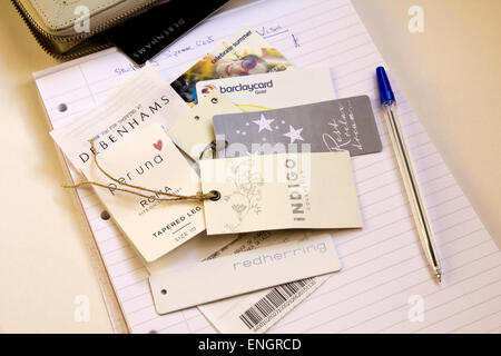 Price Tags, clothing tags, spending cost on note pad, pen. Stock Photo