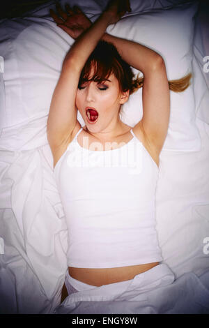 Girl laid in bed not able to sleep Stock Photo