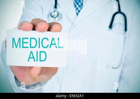 a young caucasian doctor shows a signboard with the text medical aid Stock Photo