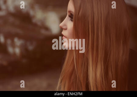 toned vintage style portrait of young woman with long blonde hair in profile Stock Photo