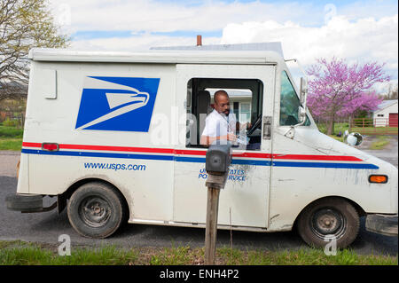 USPS mailman delivering mail to a rural home mailbox. Stock Photo