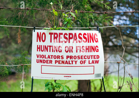 No trespassing hunting or fishing sign attached to a metal fence. Stock Photo