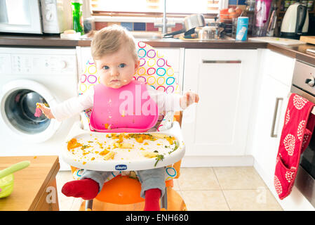 Baby led feeding a six month old baby eating messily Stock Photo