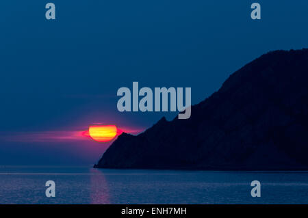 Sun setting over Ligurian Sea near the coast of Manarola, Cinque Terre, Italy