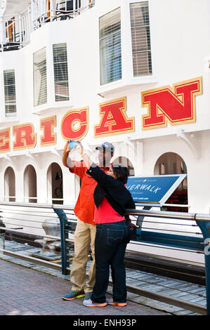 An African American couple taking a camera phone selfie in New Orleans, LA Stock Photo