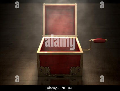 An ornate antique open jack-in-the-box mad of red wood and gold trimmings on a dark studio background under a spotlight Stock Photo