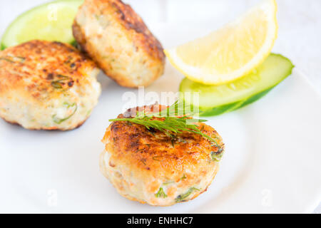 Homemade fish cakes with dill and lemon on white plate Stock Photo