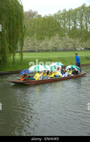 Cambridge, UK. 6th May, 2015. UK weather.  Tourists are caught in a shower and shelter under colourful umbrellas whilst punting on the River Cam in Cambridge UK.  The forecast is for a blustery day with a mix of sun and showers for the South East region. Credit Julian Eales/ Alamy Live News Stock Photo