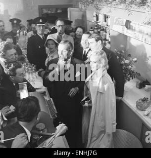 American actress Marilyn Monroe and Sir Laurence Olivier seek refuge from the waiting photographers behind a counter at Heathrow Airport. Monroe had just flown into London with her husband, playwright Arthur Miller who is pictured behind with Vivien Leigh Stock Photo