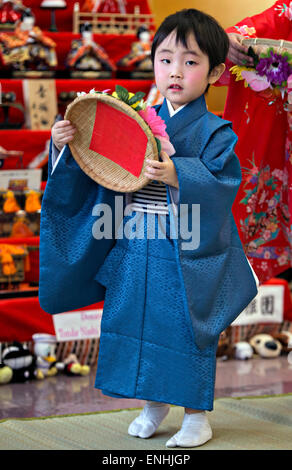 A young Japanese girl is dressed in traditional kimono during the Hinamatsuri or Hina Doll Festival at the Shinnanyo Fureai Center March 7, 2015 in Shunan City, Japan. The festival is a day in Japan when parents celebrate their daughter's happiness, growth and good health. Stock Photo
