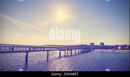 Vintage toned pier against sun, Heringsdorf in Germany. Stock Photo