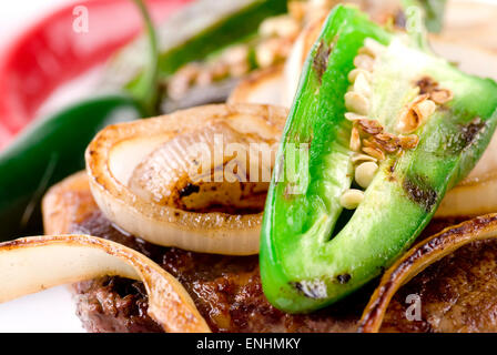 Beef steak with jalapeno and sliced onion close up. Stock Photo