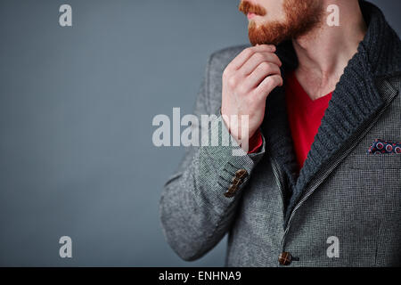Pensive young man in smart casualwear touching his beard Stock Photo