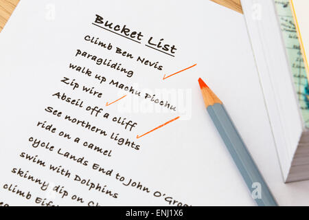 English person's Bucket list of things to do written on notepaper with some achievements ticked off in red. Wishful thinking future ambition concept Stock Photo