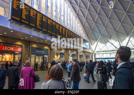 King's Cross railway station is a major London railway terminus. Passengers look at departures board Stock Photo