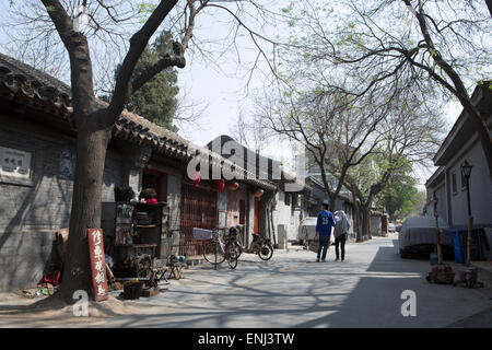 A traditional hutong (narrow street or alleyway) bordered by courtyard homes in central Beijing. Stock Photo