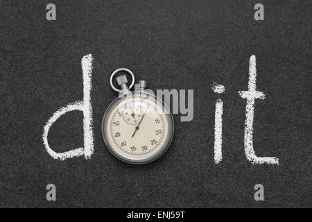 do it phrase handwritten on chalkboard with vintage precise stopwatch used instead of O Stock Photo