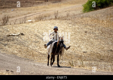 Jordan Valley, West Bank, Palestinian Territory. 6th May, 2015. A Palestinian Bedouin boy rides a donkey outside his family's tent in the Jordan valley, near the West Bank town of Tubas, on May 6, 2015. Besieged Palestinian communities in the occupied West Bank's Jordan Valley have called on the international community to immediately intervene to halt Israeli military training in the area, which has already resulted in the temporary deportation of residents from four villages from their homes and threatens the future livelihood of these communities (Credit Image: © Shadi Hatem/APA Images/ZUMA Stock Photo