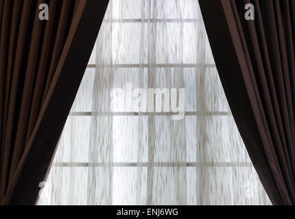 Brown curtain with translucent fabric on the window of living room. Stock Photo