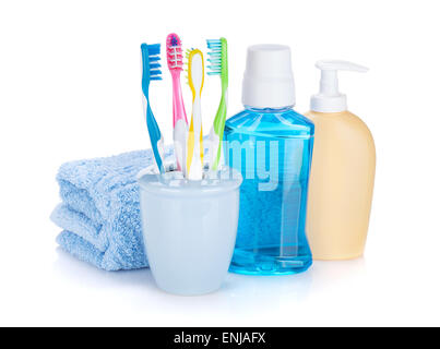Four colorful toothbrushes, cosmetics bottles and towel. Isolated on white background Stock Photo