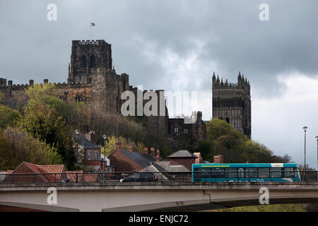 A bus driving though Durham with Durham Cathedral and Durham Castle in the background Stock Photo