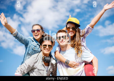 smiling teenagers in sunglasses having fun outside Stock Photo