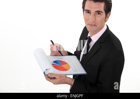 Man holding pie-chart and pen Stock Photo