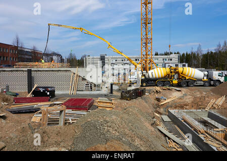 Building under construction with trucks delivering concrete, Finland Stock Photo