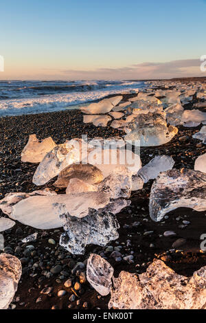 Broken ice from washed upiIcebergs on Jokulsarlon black beach at sunrise, Jokulsarlon, south east Iceland, Iceland Stock Photo