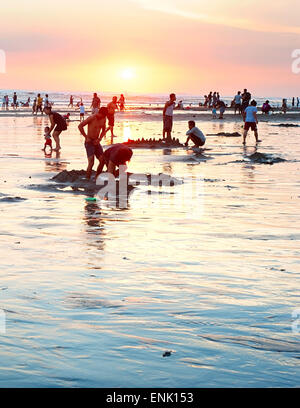 Local people resting at the ocean beach on Bali island. Stock Photo