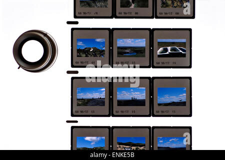 A sheet of  framed 35mm colour transparency  film slides on a light box with eye loupe Stock Photo