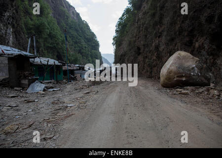 Kobani, Kobani, Nepal. 5th May, 2015. View of a destroyed village abandoned by people as we can see a huge stones fell from the mountain on the Araniko Road near the Kobani Village (Tibetan Border).Isolated Nepalese Villagers still waiting for help and worry about an other earthquake happen.Most of the houses from ''Dolalgat'' to ''Kobani'' (around 65km) collapsed, destroyed by huge stones fell from the mountains, (and stones are still falling as now), around 5 or 6 earthquakes are felt every day and night, and people didn't get any help from anyone, the phone network doesn't work, they got Stock Photo