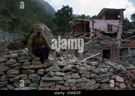 Kobani, Kobani, Nepal. 5th May, 2015. A man is pictured as he collect entire brick in order to build his house behind him on the Araniko Road near the Kobani Village (Tibetan Border).Isolated Nepalese Villagers still waiting for help and worry about an other earthquake happen.Most of the houses from ''Dolalgat'' to ''Kobani'' (around 65km) collapsed, destroyed by huge stones fell from the mountains, (and stones are still falling as now), around 5 or 6 earthquakes are felt every day and night, and people didn't get any help from anyone, the phone network doesn't work, they got enough food for Stock Photo